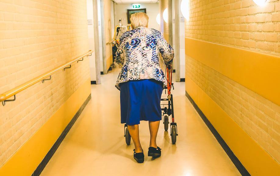 Bewoner van Warande met rollator in de gang