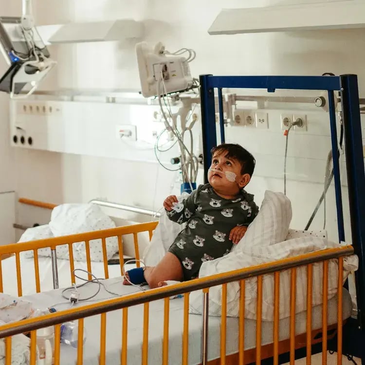 Kind in ziekenhuis bed kijkt omhoog naar de plafond projectie met de Qwiek.up