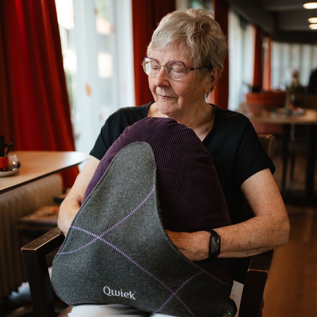 Bewoner houd ontspannen de Qwiek.embrace vast.