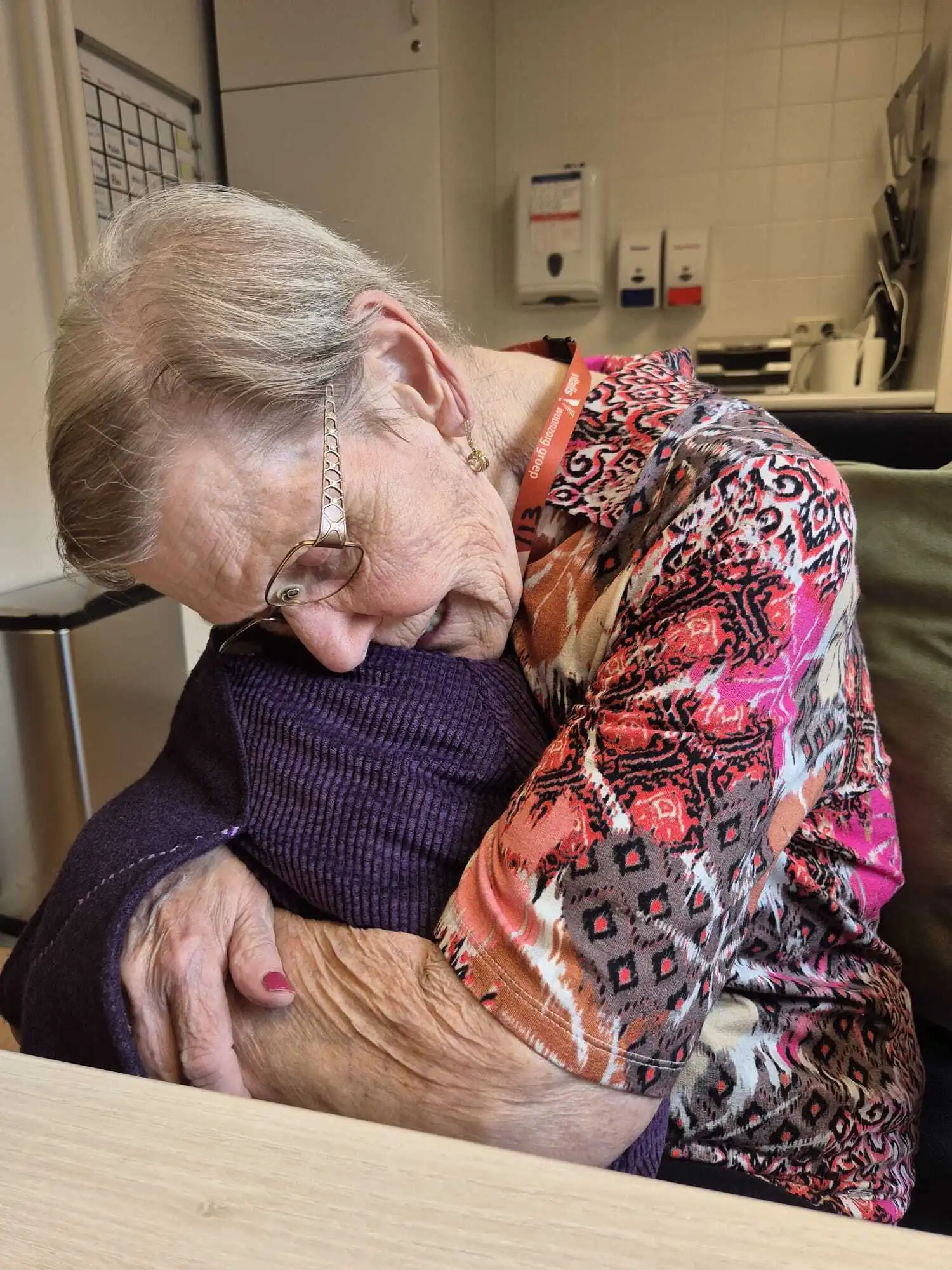 Bewoner houdt de Qwiek.embrace stevig vast en ervaart een gevoel van geborgenheid.